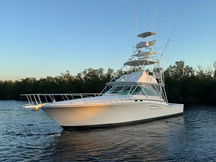  Yacht Photos Pics 1999 Cabo 45 Express yacht on calm water at sunset.