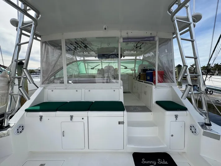  Yacht Photos Pics 1999 Cabo 45 Express boat interior with green cushions and storage compartments.