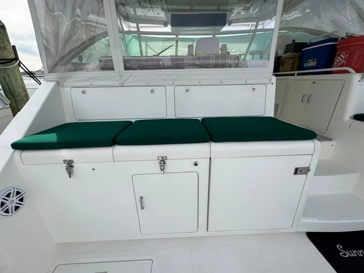  Yacht Photos Pics 1999 Cabo 45 Express boat interior with green cushioned seating and storage compartments.