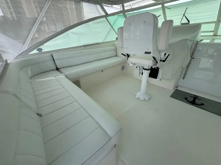  Yacht Photos Pics 1999 Cabo 45 Express boat interior with white seating and helm chair.