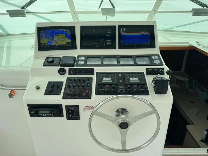  Yacht Photos Pics 1999 Cabo 45 Express helm with navigation screens and controls.