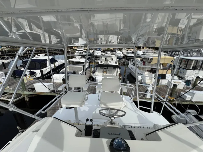  Yacht Photos Pics 1999 Cabo 45 Express yacht helm with marina view, featuring dual seats and navigation equipment.