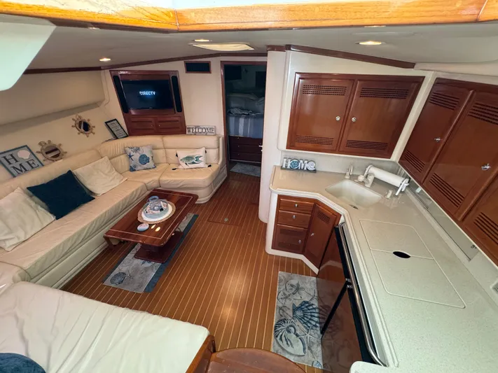  Yacht Photos Pics Interior of 1999 Cabo 45 Express yacht with cozy seating and wooden cabinetry.