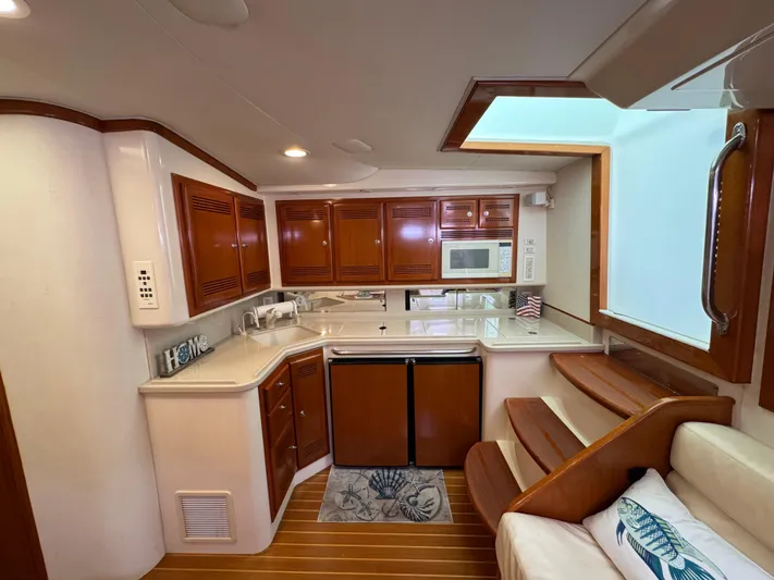  Yacht Photos Pics Luxurious 1999 Cabo 45 Express yacht interior with modern kitchen and wooden cabinetry.