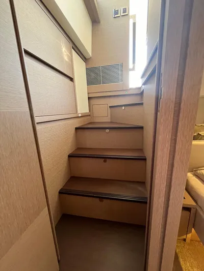 Yacht Photos Pics Interior stairs of a 2018 Prestige 520 yacht, featuring wooden steps and modern design.