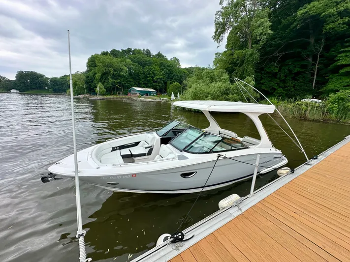 Yacht Photos Pics 2023 Regal 2800 Bowrider boat docked on a serene lake with lush greenery.