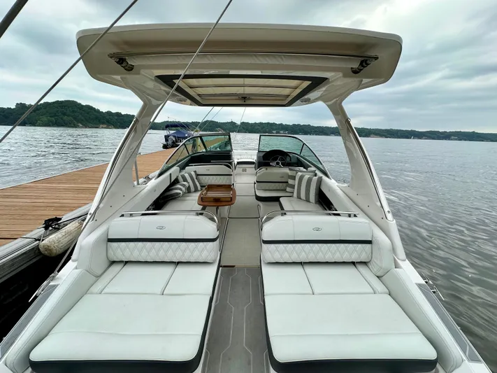  Yacht Photos Pics 2023 Regal 2800 Bowrider boat with luxurious seating, docked by a scenic lake.