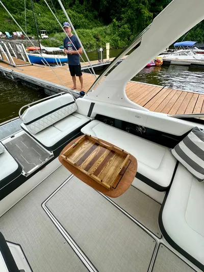  Yacht Photos Pics 2023 Regal 2800 Bowrider interior with wooden table, docked by a wooden pier.