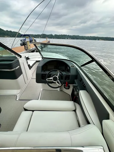  Yacht Photos Pics 2023 Regal 2800 Bowrider interior with steering wheel, docked on a calm lake.