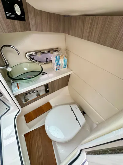  Yacht Photos Pics 2023 Regal 2800 Bowrider bathroom with modern sink, toilet, and wooden accents.