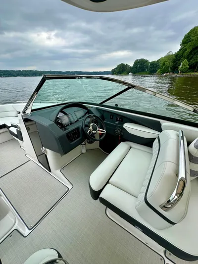  Yacht Photos Pics 2023 Regal 2800 Bowrider interior with sleek dashboard and comfortable seating on a serene lake.