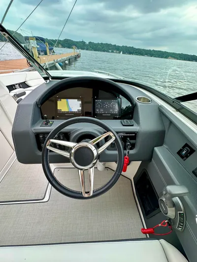  Yacht Photos Pics 2023 Regal 2800 Bowrider dashboard with steering wheel and digital displays, docked by a lake.