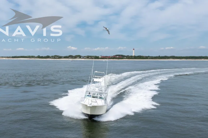 Pipe Dream Yacht Photos Pics 2005 Topaz 32 Express yacht cruising on open water near a lighthouse.