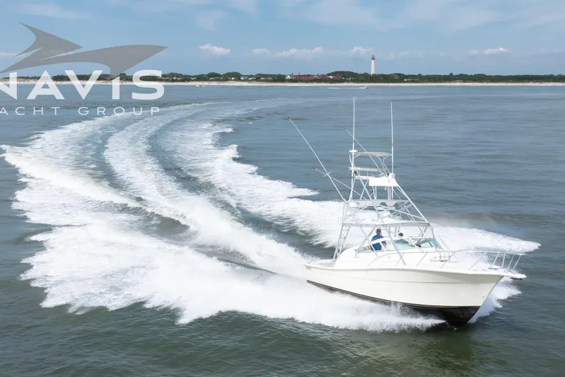 Pipe Dream Yacht Photos Pics 2005 Topaz 32 Express yacht cruising on open water near a lighthouse.