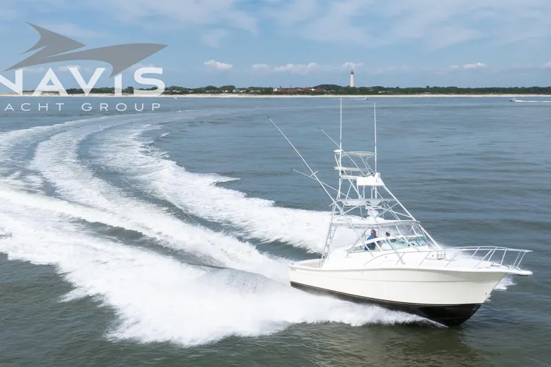 Pipe Dream Yacht Photos Pics 2005 Topaz 32 Express yacht cruising on open water with coastal backdrop.