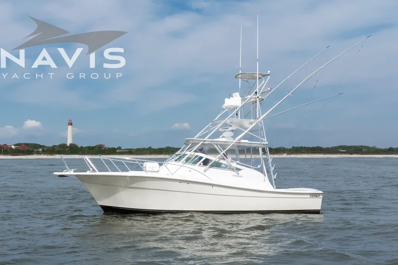 Pipe Dream Yacht Photos Pics 2005 Topaz 32 Express yacht on water with lighthouse in background.