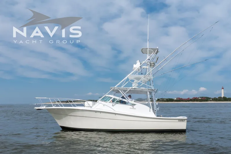 Pipe Dream Yacht Photos Pics 2005 Topaz 32 Express yacht on open water with lighthouse in background.