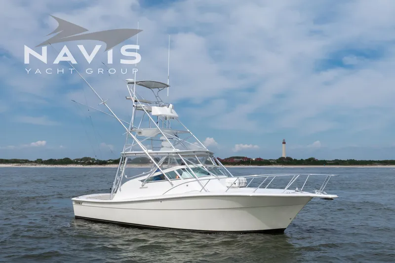 Pipe Dream Yacht Photos Pics 2005 Topaz 32 Express yacht on water with lighthouse in background.