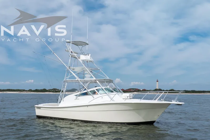 Pipe Dream Yacht Photos Pics 2005 Topaz 32 Express yacht on water with lighthouse in background.