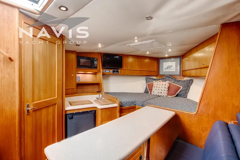 Pipe Dream Yacht Photos Pics 2005 Topaz 32 Express yacht interior with cozy cabin, kitchenette, and wooden finishes.