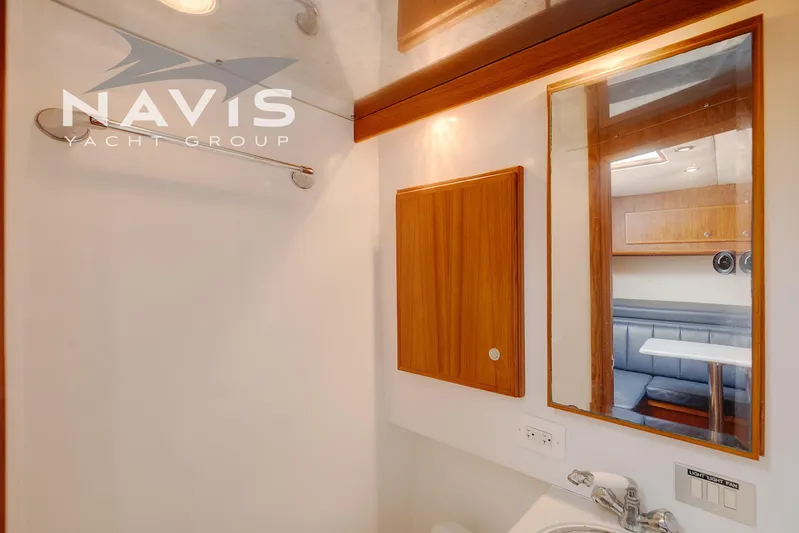Pipe Dream Yacht Photos Pics 2005 Topaz 32 Express yacht bathroom with wooden cabinet, mirror, and sink.