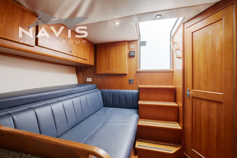 Pipe Dream Yacht Photos Pics Interior of 2005 Topaz 32 Express yacht with wooden cabinetry and blue seating.