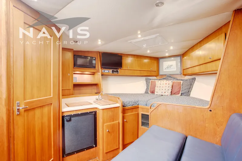 Pipe Dream Yacht Photos Pics 2005 Topaz 32 Express yacht interior with cozy cabin, kitchenette, and wooden cabinetry.