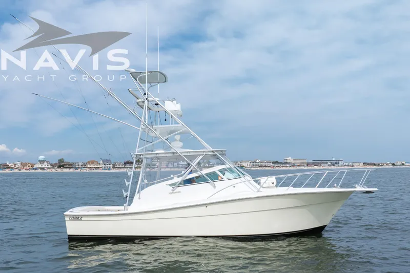 Pipe Dream Yacht Photos Pics 2005 Topaz 32 Express yacht on calm water with coastal background.