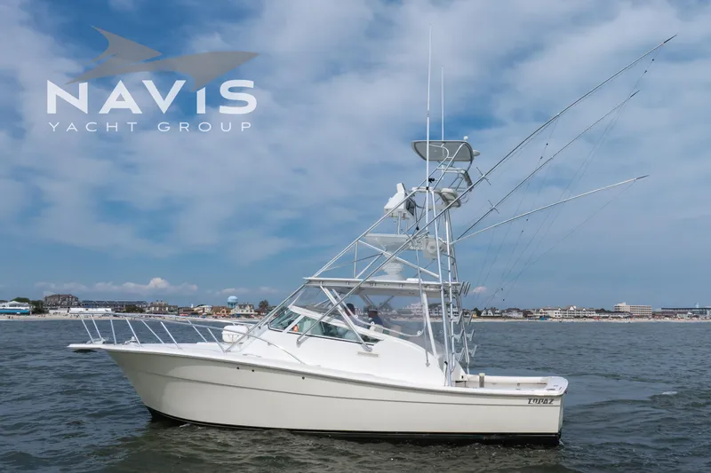 Pipe Dream Yacht Photos Pics 2005 Topaz 32 Express yacht on water, Navis Yacht Group logo, coastal background.