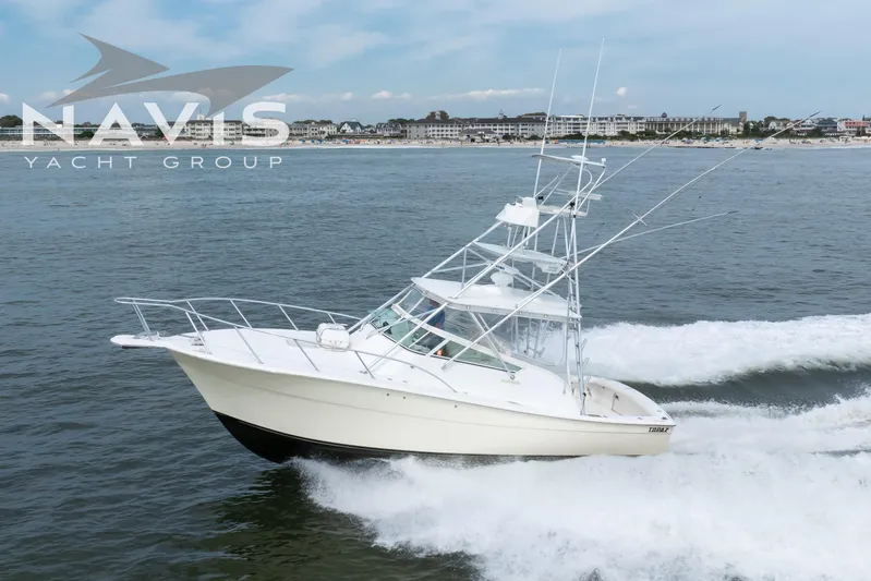 Pipe Dream Yacht Photos Pics 2005 Topaz 32 Express yacht cruising on open water near coastline.