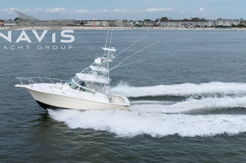 Pipe Dream Yacht Photos Pics 2005 Topaz 32 Express yacht cruising on open water near coastal town.