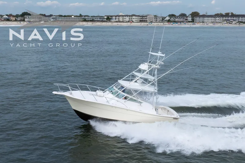 Pipe Dream Yacht Photos Pics 2005 Topaz 32 Express yacht cruising near shoreline, Navis Yacht Group branding visible.