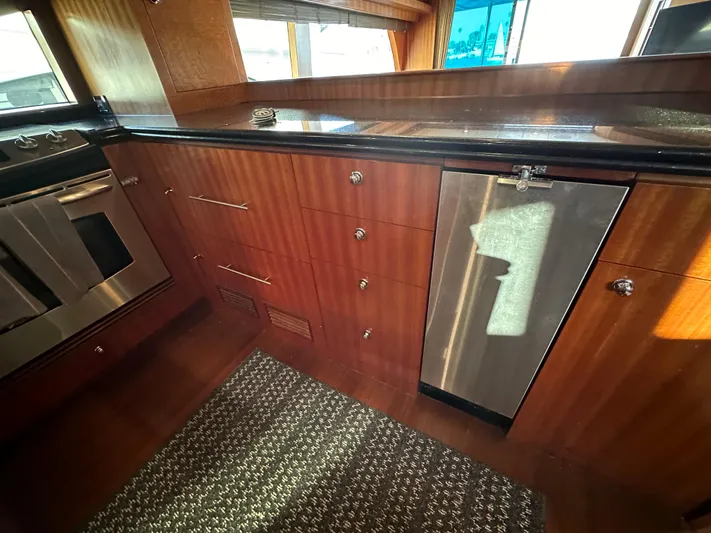 Stella Maris II Yacht Photos Pics Interior of 2007 Horizon 73 Motor Yacht kitchen with wood cabinetry and stainless steel appliances.