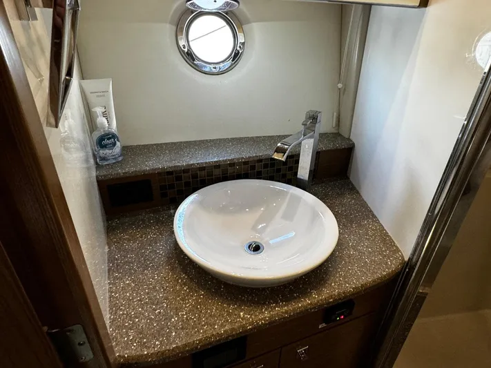  Yacht Photos Pics Bathroom sink area in a 2014 Cruisers Yachts 45 Cantius, featuring a round basin and porthole window.