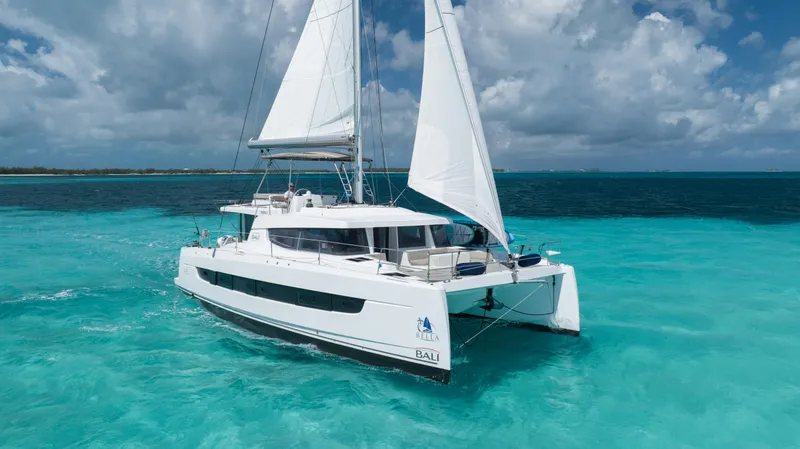 Bella Yacht Photos Pics Sailing catamaran Bali 4.8, 2021 model, cruising in turquoise ocean waters under a cloudy sky.