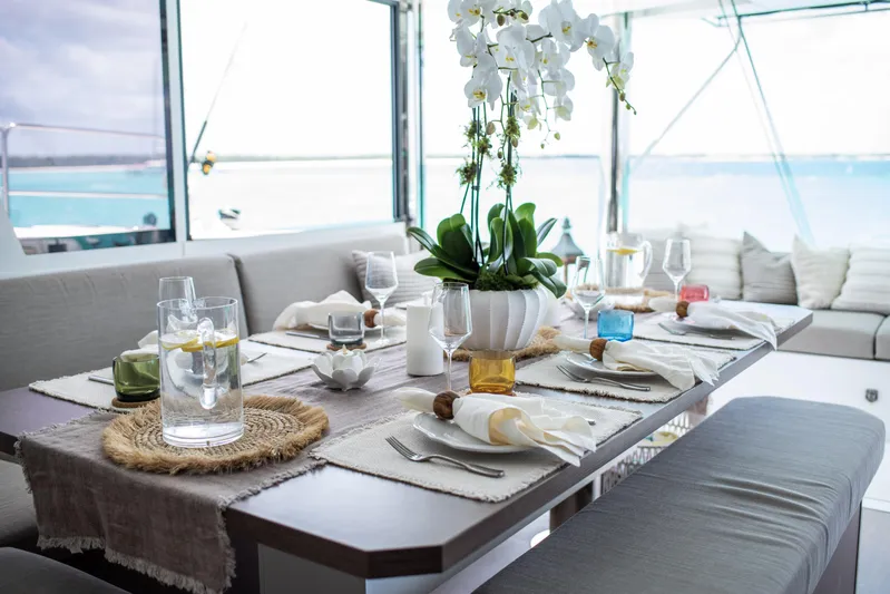 Bella Yacht Photos Pics Elegant dining setup on Bali 4.8 yacht, featuring orchids and ocean view, 2021 model.