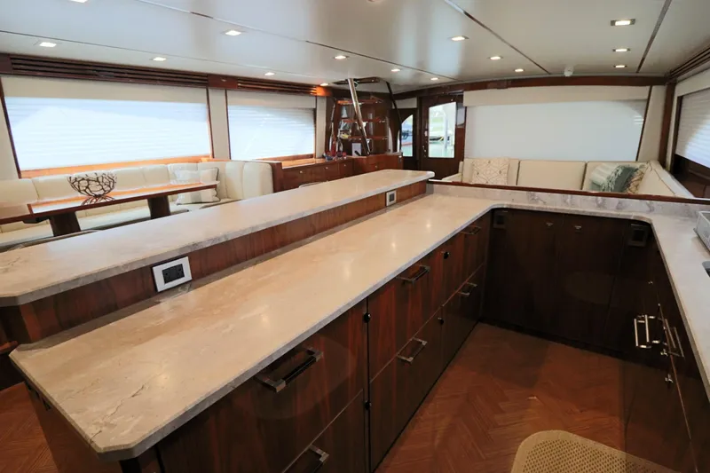 Stress Release Yacht Photos Pics Luxurious interior of 2017 Viking 80 Enclosed Bridge yacht with modern kitchen and seating area.