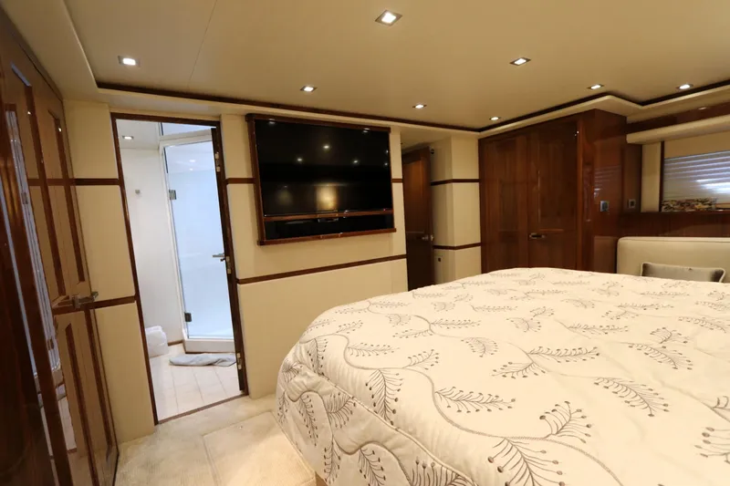 Stress Release Yacht Photos Pics Luxurious bedroom interior of 2017 Viking 80 Enclosed Bridge yacht with elegant wood finishes.