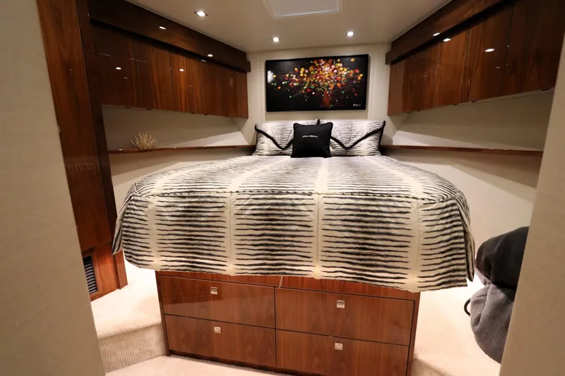 Stress Release Yacht Photos Pics Luxurious bedroom interior of 2017 Viking 80 Enclosed Bridge yacht with elegant wood finishes.