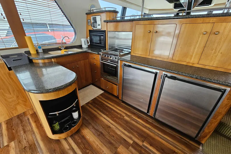 Paradox Yacht Photos Pics Luxurious kitchen interior of 2000 Carver 530 Voyager Pilothouse yacht with wood cabinetry and modern appliances.