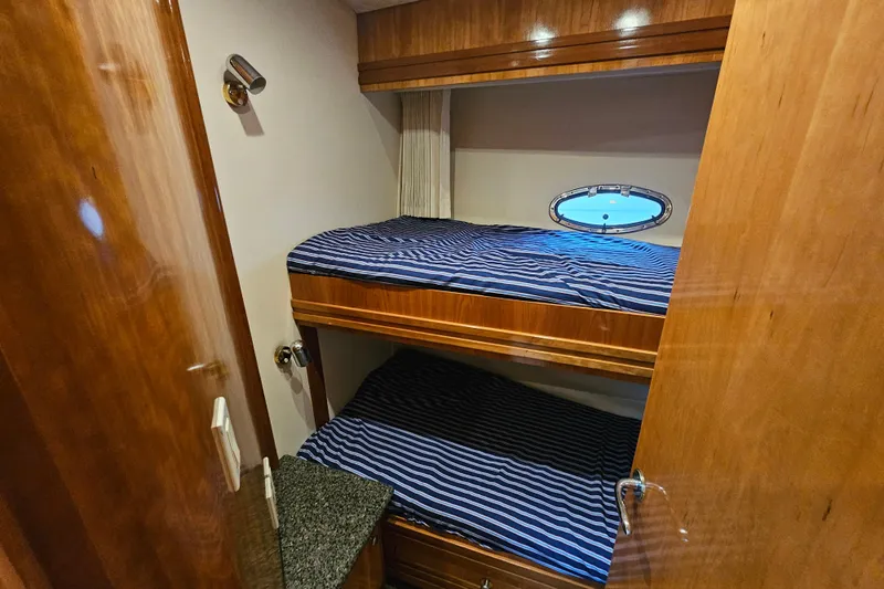 Paradox Yacht Photos Pics Bunk beds in 2000 Carver 530 Voyager Pilothouse cabin with striped bedding and porthole.