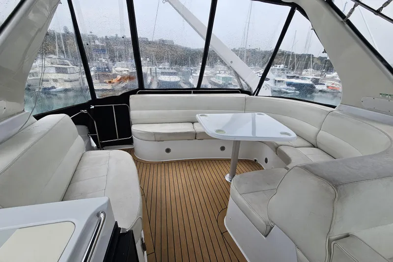 Paradox Yacht Photos Pics Interior of 2000 Carver 530 Voyager Pilothouse with white seating and wooden flooring.