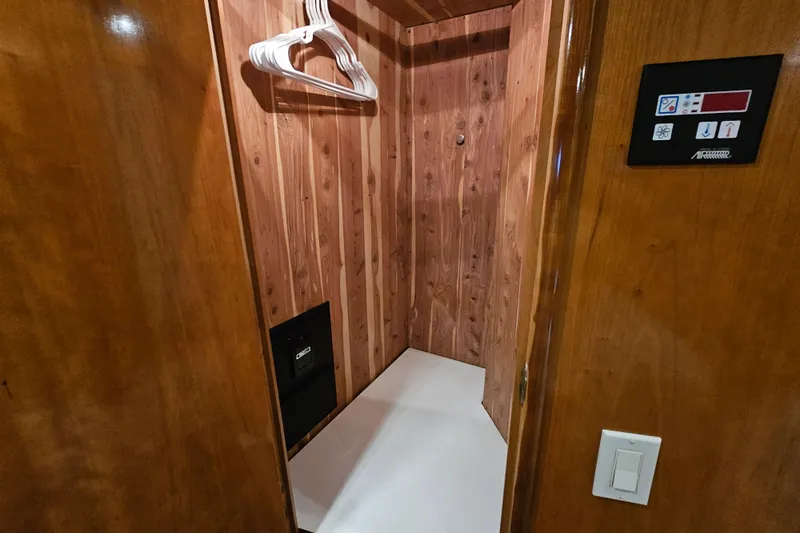 Paradox Yacht Photos Pics Wood-paneled closet interior on 2000 Carver 530 Voyager Pilothouse yacht with hangers and control panel.