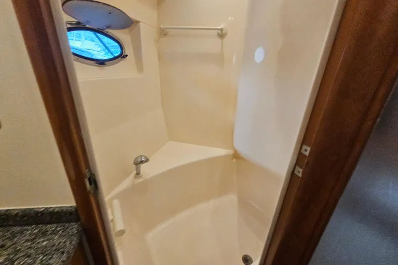 Paradox Yacht Photos Pics Shower area inside 2000 Carver 530 Voyager Pilothouse yacht, featuring a porthole window.