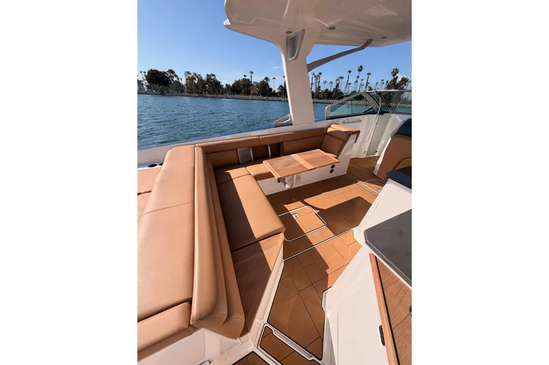 Wonder Why Yacht Photos Pics Luxurious 2022 Aviara AV32 I/O boat interior with tan seating and wooden accents on a sunny day.