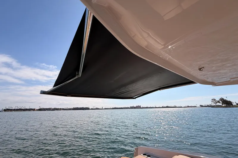 Wonder Why Yacht Photos Pics 2022 Aviara AV32 I/O boat with extended sunshade over calm waters.