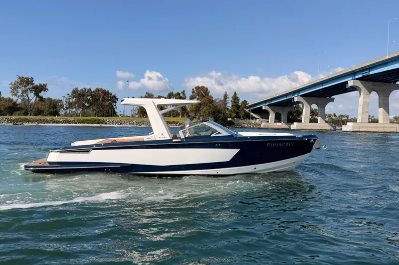 Wonder Why Yacht Photos Pics 2022 Aviara AV32 I/O boat cruising near a bridge on a sunny day.