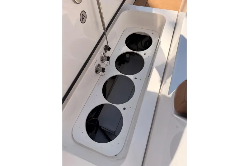 Wonder Why Yacht Photos Pics Aviara AV32 I/O 2022 boat storage compartment with cup holders and control knobs.