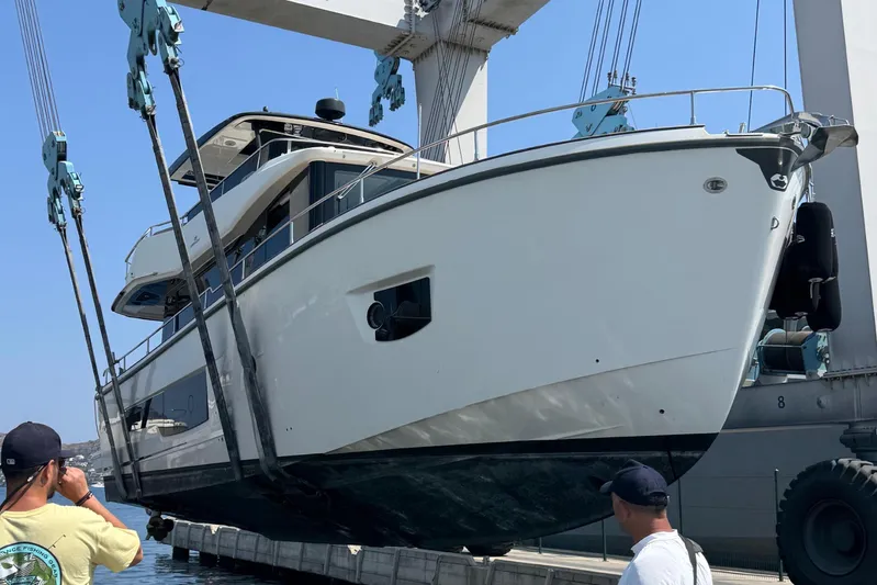  Yacht Photos Pics 2022 Cranchi T55 Trawler yacht being lifted by crane at a marina.