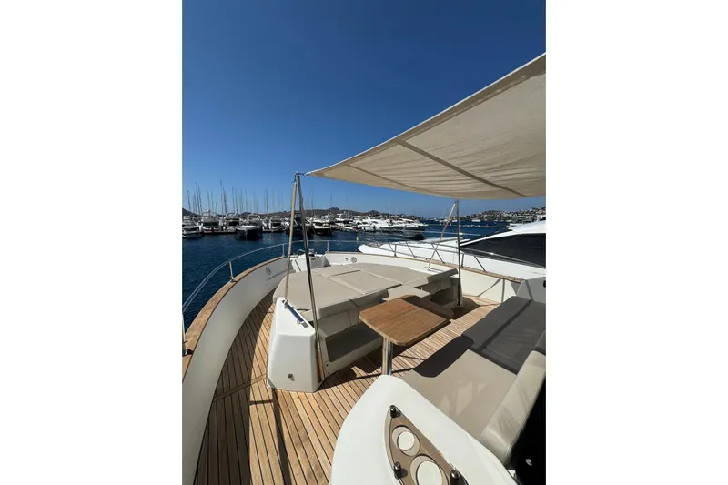  Yacht Photos Pics 2022 Cranchi T55 Trawler yacht deck with seating, table, and sunshade in marina.